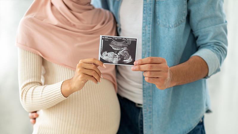 Image of woman and man holding sonogram together