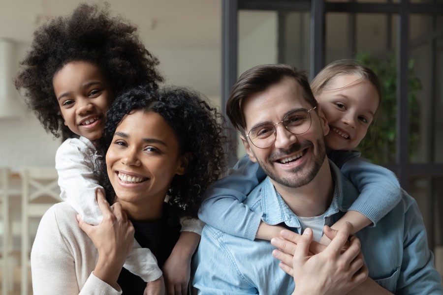 Image of diverse family, smiling at the camera.